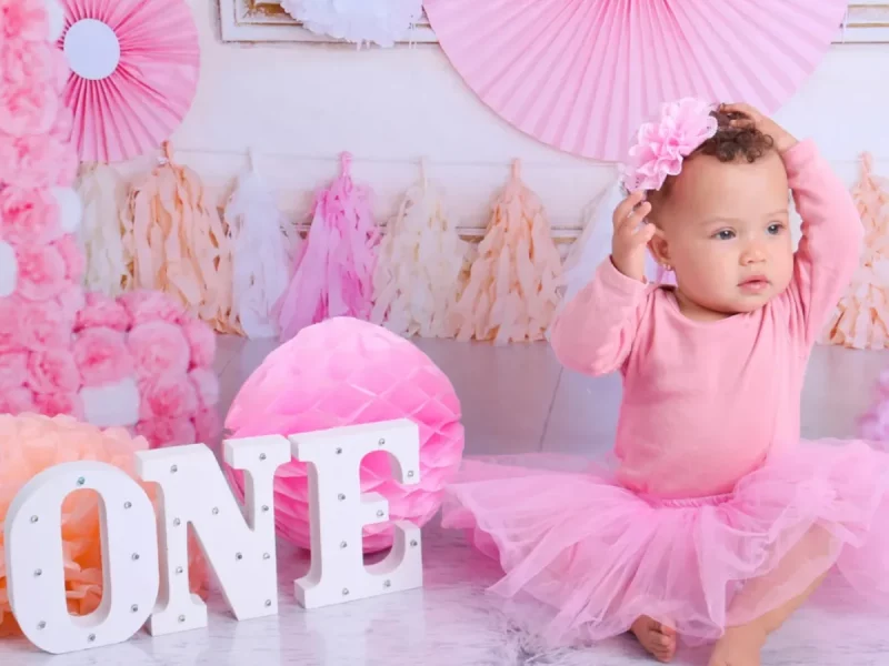 Bebé con vestido rosa en una sesión de cumpleaños sin tarta
